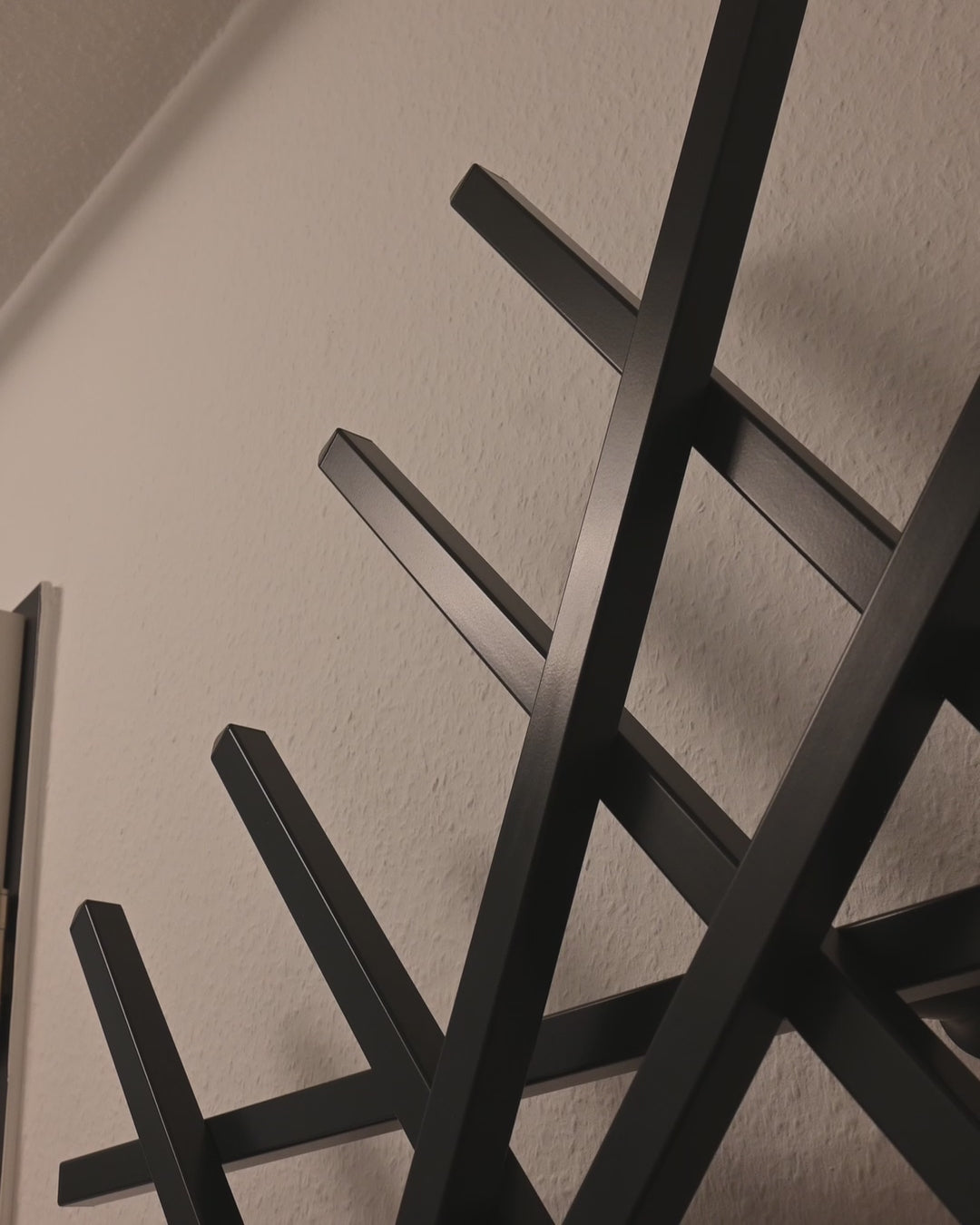 Nahaufnahme der Treecado Designer-Wandgarderobe aus Aluminium in Anthrazitgrau (RAL7016). Zeigt hochwertige Verarbeitung, feine Beschichtung und modernes minimalistisches Design, begleitet von ruhiger Klaviermusik.