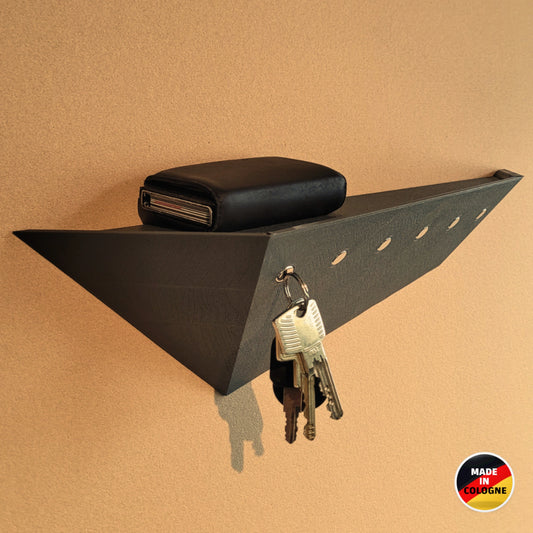Schrägansicht vom grauen Treeboard Schlüsselhalter für die Wand mit magnetischer Schlüsselaufbewahrung und Ablagefläche. Made in Cologne.