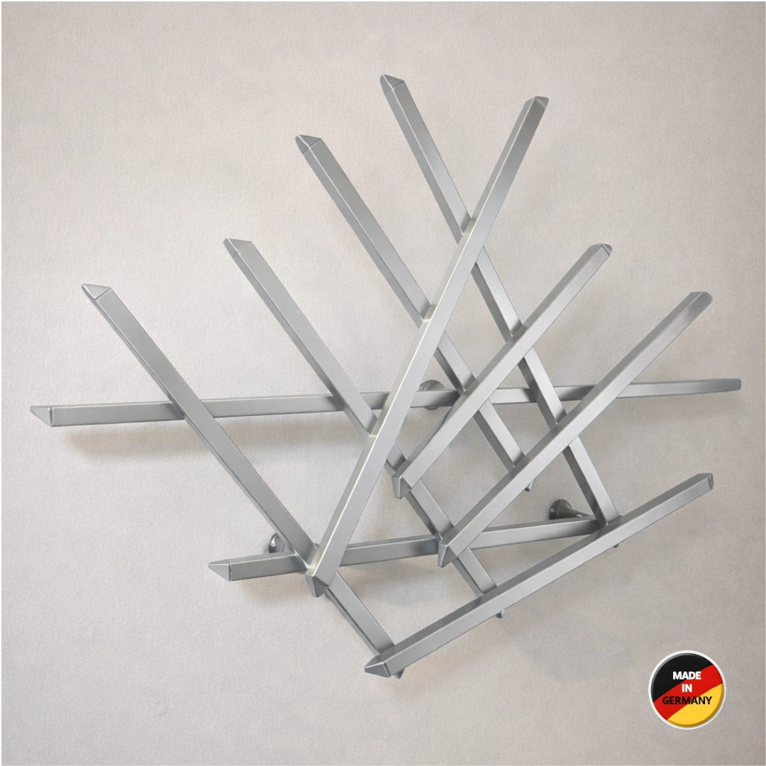 Treecado Designer-Wandgarderobe aus Aluminium in Weißaluminium (RAL9006), stilvoll an einer hellen Wand montiert, leicht von links fotografiert. Modernes, minimalistisches Design. Made in Germany.